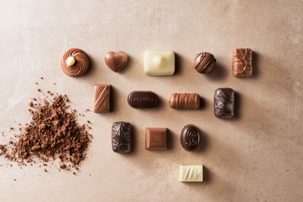 Belgische Pralinen neben Kakaopulver von oben